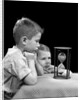 1940s two boys waiting watching sand falling in hourglass by Anonymous