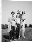 1960s smiling family portrait standing on grass mother father three children by Anonymous