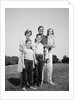 1960s smiling family portrait standing on grass mother father three children by Anonymous