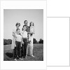 1960s smiling family portrait standing on grass mother father three children by Anonymous