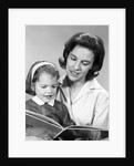 1960s woman reading story book to girl child by Anonymous