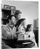 1960s happy family looking at slides on slide projector by Anonymous