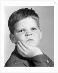 1960s little boy making angry funny facial expression looking at camera by Anonymous
