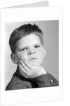 1960s little boy making angry funny facial expression looking at camera by Anonymous