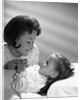 1960s daughter with mother tucking into bed by Anonymous
