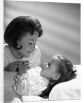 1960s daughter with mother tucking into bed by Anonymous