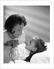 1960s daughter with mother tucking into bed by Anonymous