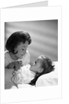 1960s daughter with mother tucking into bed by Anonymous