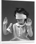 1940s child wearing blind fold with hands up in the air by Anonymous
