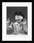 1940s child wearing blind fold with hands up in the air by Anonymous