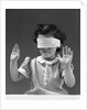 1940s child wearing blind fold with hands up in the air by Anonymous
