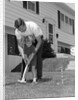 1960s father and young daughter playing croquet in yard by Anonymous