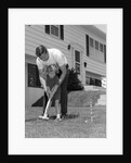 1960s father and young daughter playing croquet in yard by Anonymous