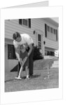 1960s father and young daughter playing croquet in yard by Anonymous