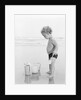 1960s 1970s child toddler standing in sand water bucket shovel by Anonymous