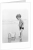 1960s 1970s child toddler standing in sand water bucket shovel by Anonymous