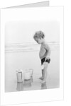 1960s 1970s child toddler standing in sand water bucket shovel by Anonymous