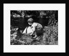 1920s boy putting toy sailboat into stream by Anonymous