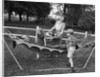 1950s mom & kids serving dad in hammock by Anonymous