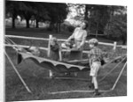 1950s mom & kids serving dad in hammock by Anonymous