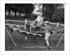 1950s mom & kids serving dad in hammock by Anonymous