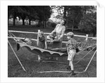 1950s mom & kids serving dad in hammock by Anonymous