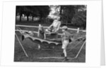 1950s mom & kids serving dad in hammock by Anonymous