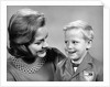 1960s portrait mother with arm around son dressed in school uniform with bow tie & emblem crest on jacket mom pearl lace collar by Anonymous
