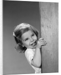 1960s child little girl smiling peeking around corner by Anonymous