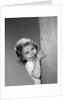 1960s child little girl smiling peeking around corner by Anonymous