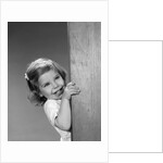 1960s child little girl smiling peeking around corner by Anonymous