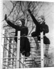 1930s two children waving while sitting on playground equipment by Anonymous