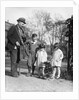 1920s group of three children watching organ grinder's monkey in costume standing on hind legs by Anonymous
