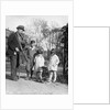 1920s group of three children watching organ grinder's monkey in costume standing on hind legs by Anonymous