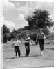1950s three girls running in grassy field by Anonymous
