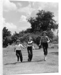 1950s three girls running in grassy field by Anonymous