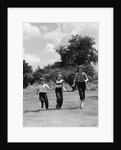 1950s three girls running in grassy field by Anonymous