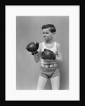 1940s boy child wearing boxing gloves standing ready to fight by Anonymous