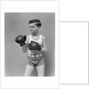 1940s boy child wearing boxing gloves standing ready to fight by Anonymous