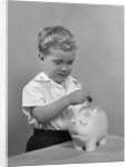 1950slittle boy putting coin into piggy bank by Anonymous
