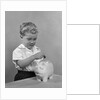 1950slittle boy putting coin into piggy bank by Anonymous