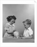 1950s little girl and boy putting coin into piggy bank by Anonymous