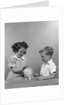 1950s little girl and boy putting coin into piggy bank by Anonymous