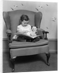 1930s little girl child in large chair with bear reading book by Anonymous