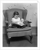 1930s little girl child in large chair with bear reading book by Anonymous