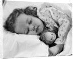 1950s child little girl sleeping in bed with doll by Anonymous