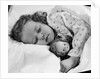 1950s child little girl sleeping in bed with doll by Anonymous