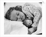 1950s child little girl sleeping in bed with doll by Anonymous