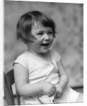 1930s smiling laughing toddler girl holding shoe by Anonymous
