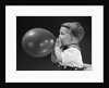 1940s boy blowing up balloon by Anonymous